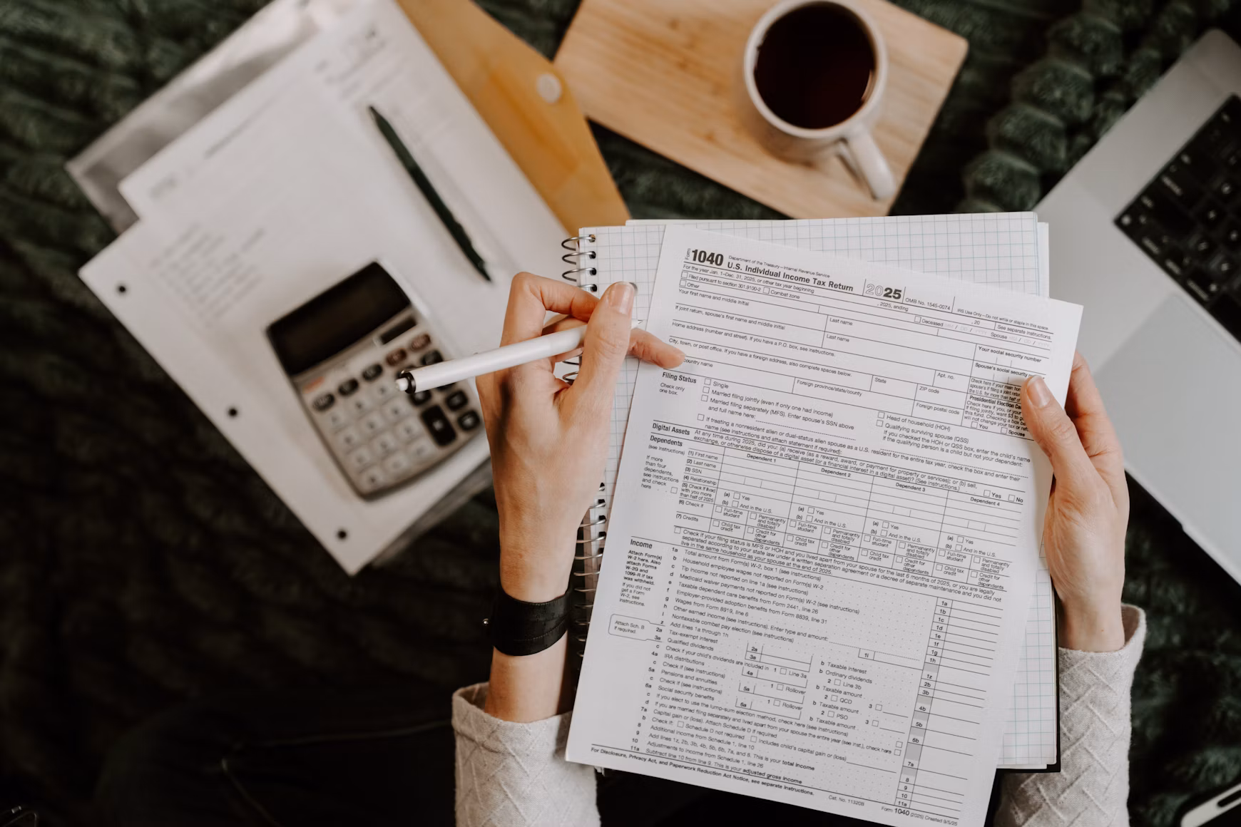 Paperwork being checked with a calculator at a home desk