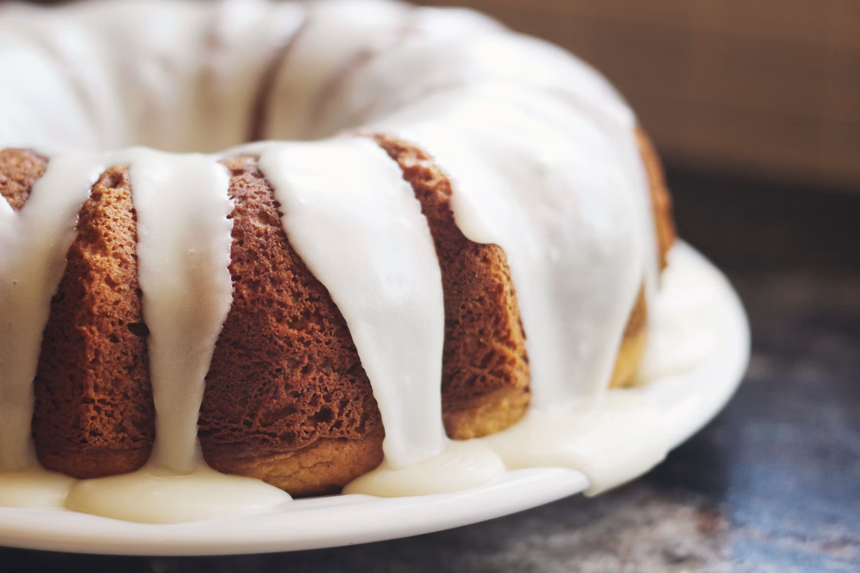Ring cake with pale icing on a kitchen counter