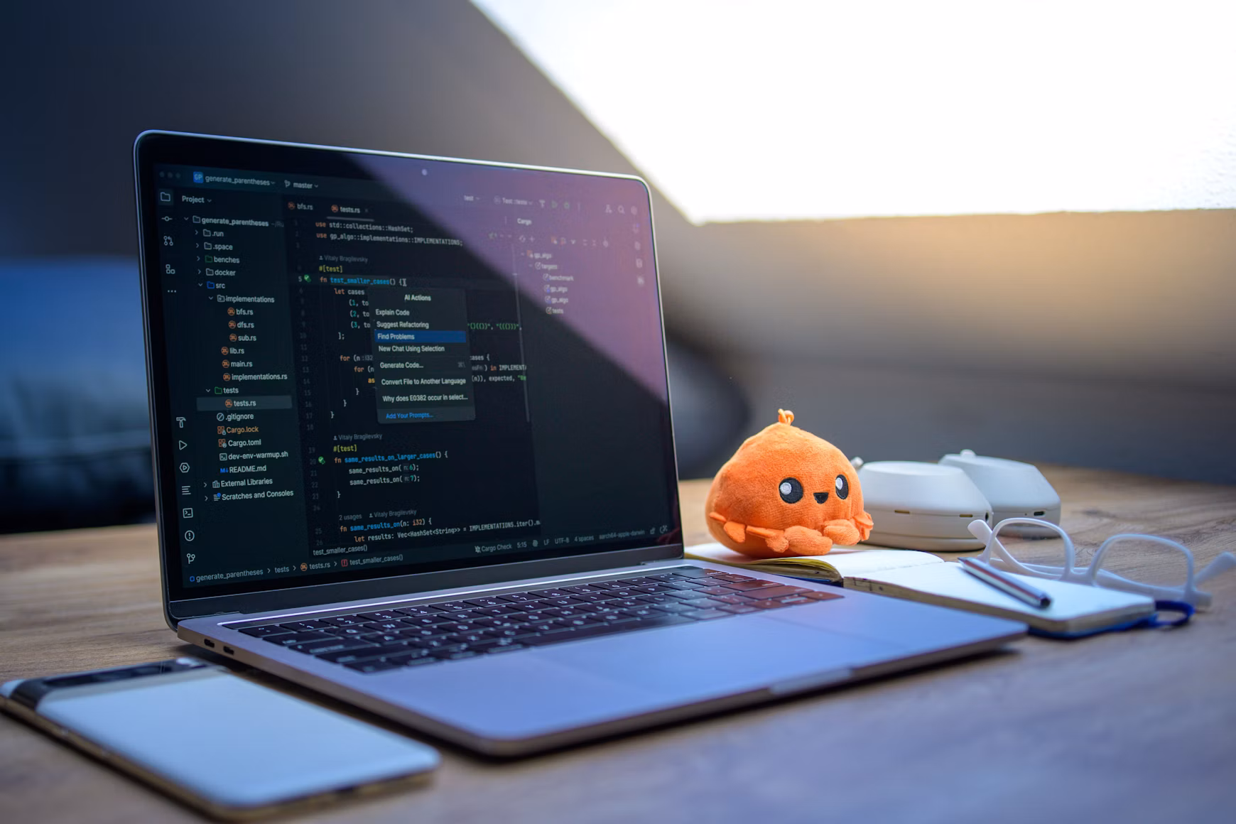 Laptop workspace with code, phone and reading glasses