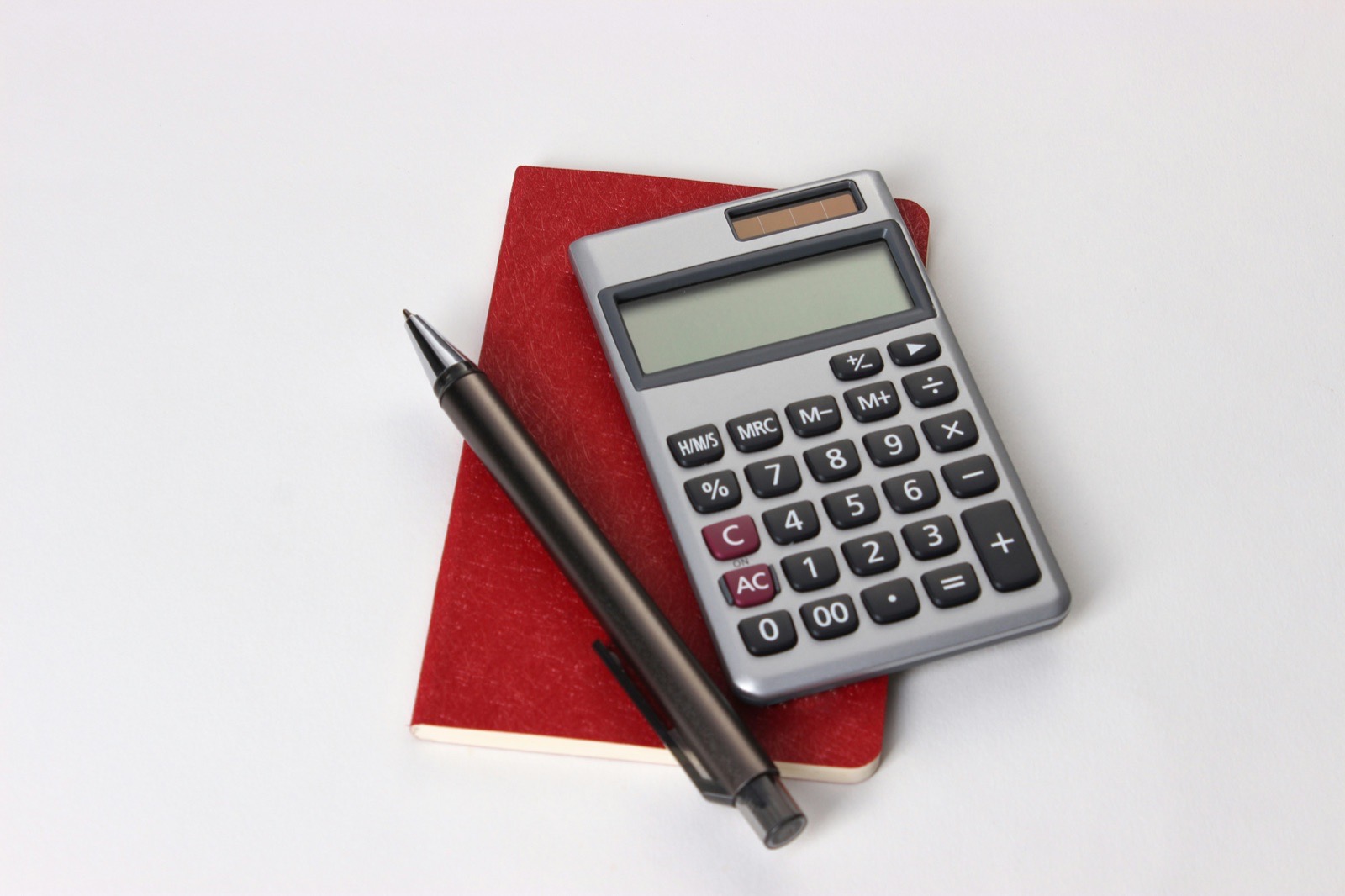 Calculator, books and pen for financial analysis.