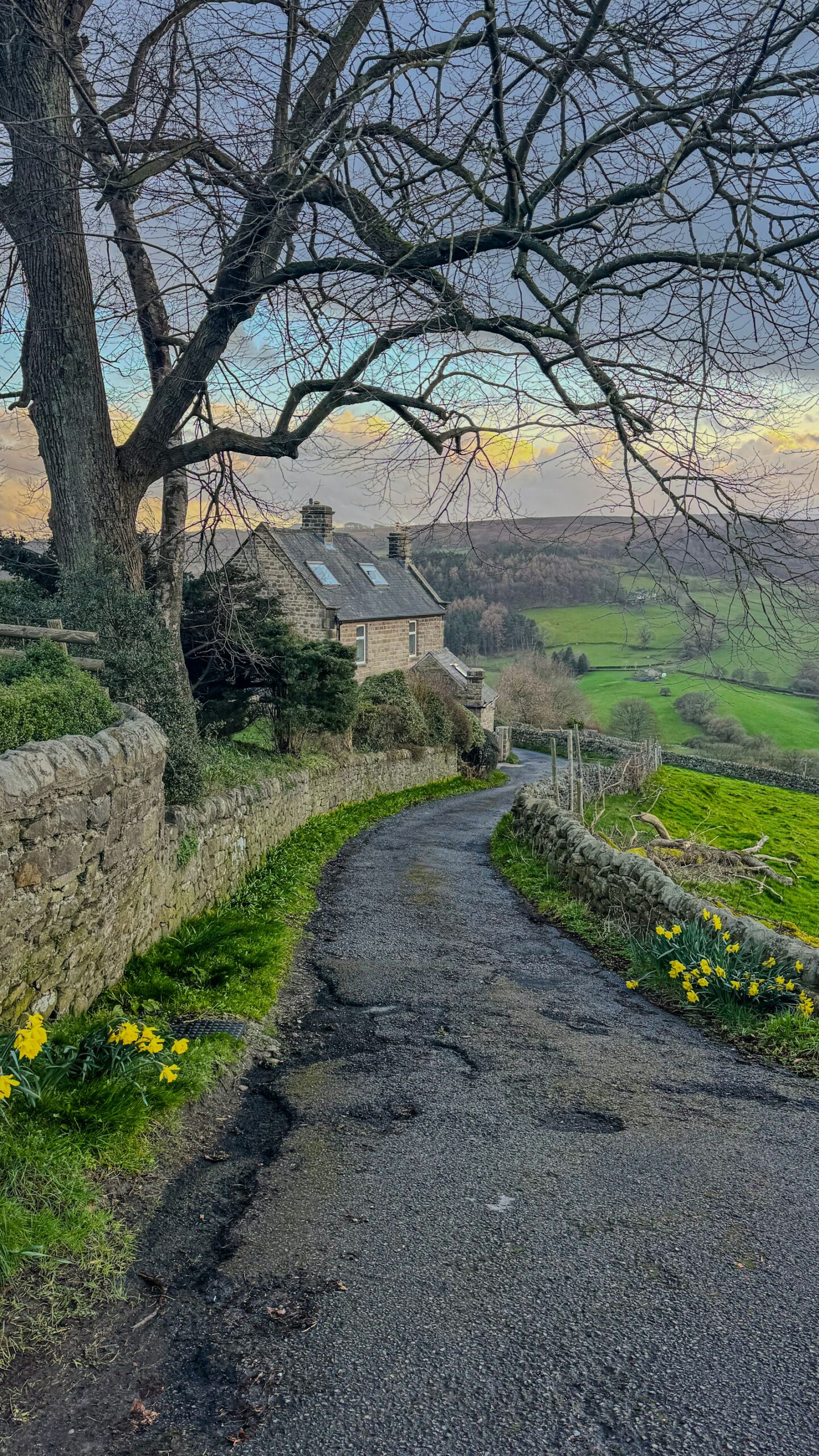 Quiet winding country road past stone houses in the UK