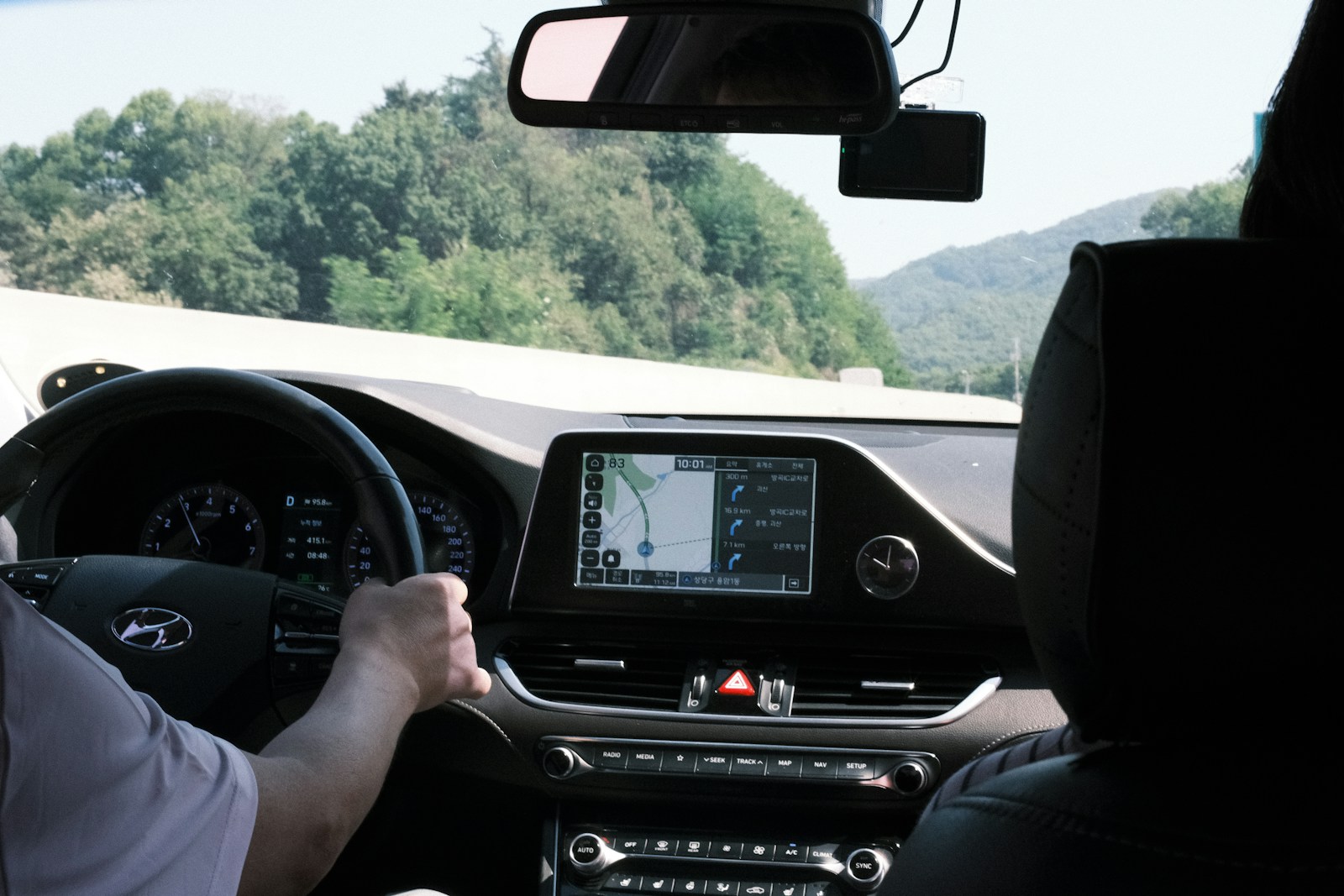 Car dashboard with navigation screen and road ahead