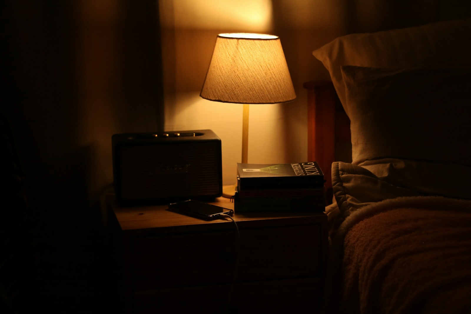 Warm bedside lamp illuminating a nightstand