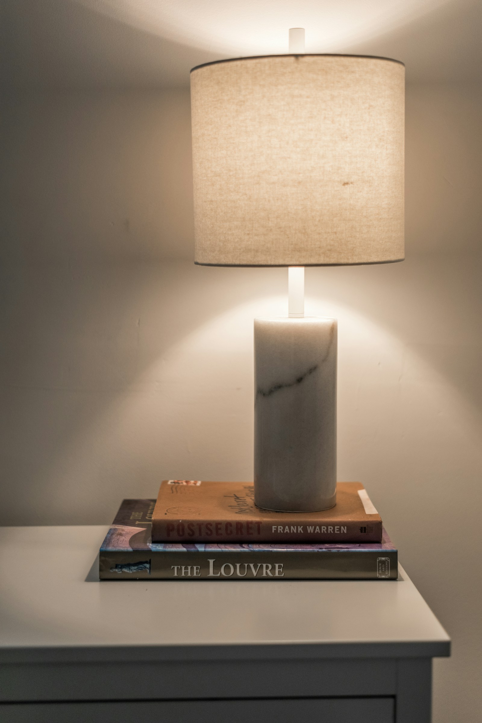 A warm lamp beside an open book at night