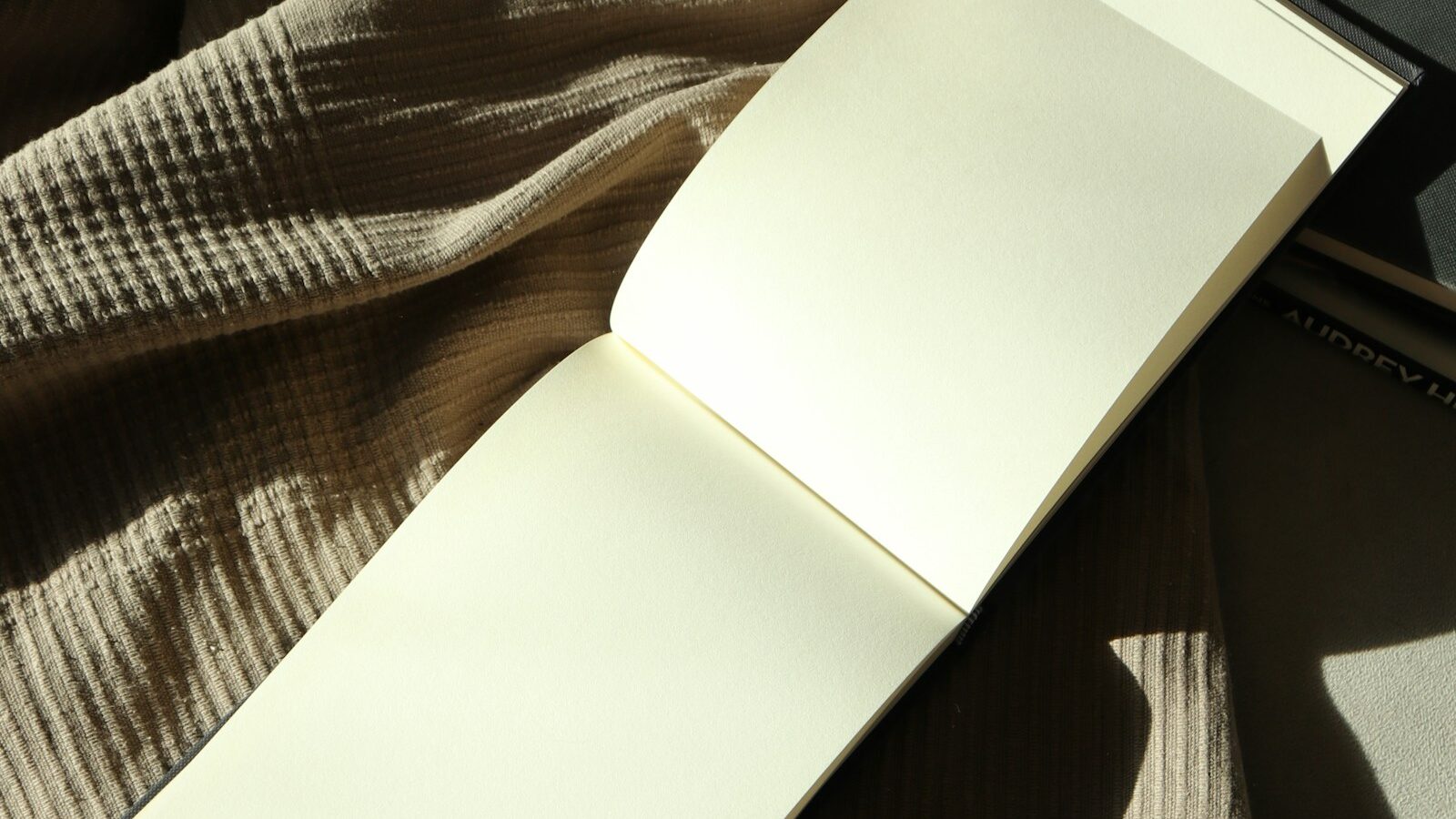 Open notebook resting on a bed in soft light